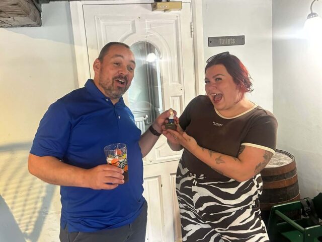 Two golf society members with their prizes in the bar