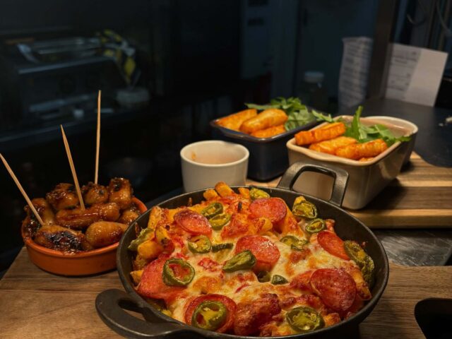 Small plates on the pass, with chorizo bites and a pan of loaded fries
