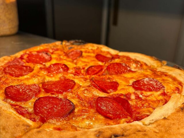 A pepperoni pizza on its slate